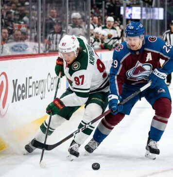 Minnesota Wild star Kirill Kaprizov (#97) engages in an intense board battle for the puck with Colorado Avalanche captain Nathan MacKinnon (#29) during Game 4 of their NHL playoff series at Xcel Energy Center on Monday, May 11, 2026.