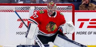 Chicago Blackhawks Trade Rumors: Connor Hellebuyck & Winnipeg Jets A photorealistic image showing goalie Connor Hellebuyck in a red Chicago Blackhawks home uniform and custom Blackhawks mask in the goal crease, illustrating potential trade rumors from the Winnipeg Jets.