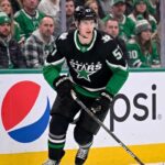 Action shot of a Dallas Stars hockey player in the neon black alternate uniform, illustrating the tough roster decisions facing management regarding Tyler Myers and the salary cap.