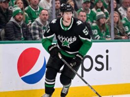 Action shot of a Dallas Stars hockey player in the neon black alternate uniform, illustrating the tough roster decisions facing management regarding Tyler Myers and the salary cap.