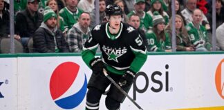 Action shot of a Dallas Stars hockey player in the neon black alternate uniform, illustrating the tough roster decisions facing management regarding Tyler Myers and the salary cap.
