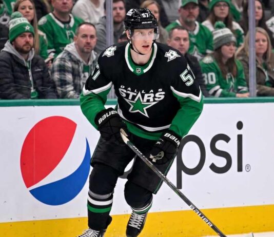 Action shot of a Dallas Stars hockey player in the neon black alternate uniform, illustrating the tough roster decisions facing management regarding Tyler Myers and the salary cap.