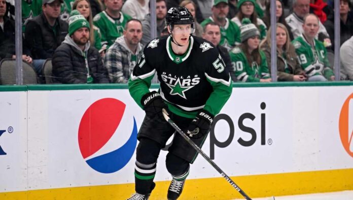 Action shot of a Dallas Stars hockey player in the neon black alternate uniform, illustrating the tough roster decisions facing management regarding Tyler Myers and the salary cap.