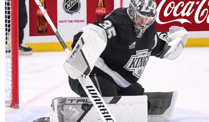 darcy-kuemper-los-angeles-kings-trade-rumors Los Angeles Kings goalie Darcy Kuemper in his black Kings jersey with number 35, making a stick save on the ice. This image relates to current NHL trade rumors concerning Kuemper's future with LA.
