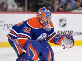 A conceptual photograph visualizing goaltender Filip Gustavsson wearing a royal blue and orange Edmonton Oilers uniform with number 32, representing the rumored NHL trade from the Minnesota Wild.