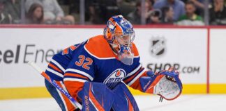 A conceptual photograph visualizing goaltender Filip Gustavsson wearing a royal blue and orange Edmonton Oilers uniform with number 32, representing the rumored NHL trade from the Minnesota Wild.