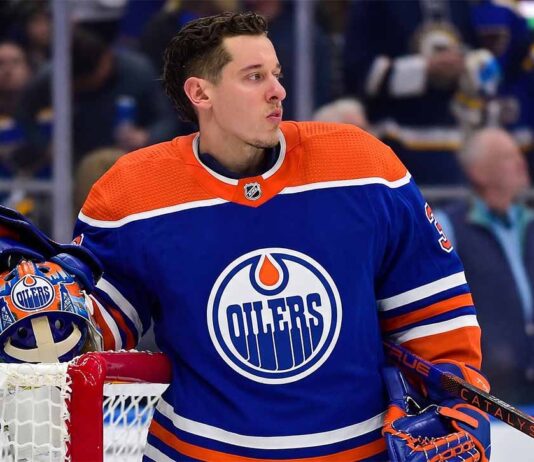 Photo-realistic mockup of Jordan Binnington wearing an Edmonton Oilers uniform and holding an Oilers-themed goalie mask, illustrating NHL trade rumors between the St. Louis Blues and Edmonton.