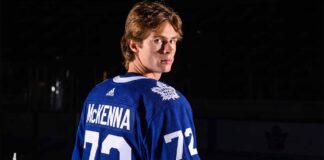 A visualization of top NHL prospect Gavin McKenna in a blue Toronto Maple Leafs jersey with 'MCKENNA' and number 72 on the back, looking over his shoulder in a dramatically lit hockey arena. Keywords: Toronto Maple Leafs, Gavin McKenna, NHL Draft.