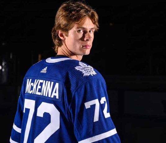 A visualization of top NHL prospect Gavin McKenna in a blue Toronto Maple Leafs jersey with 'MCKENNA' and number 72 on the back, looking over his shoulder in a dramatically lit hockey arena. Keywords: Toronto Maple Leafs, Gavin McKenna, NHL Draft.