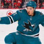 An image of Jason Robertson, wearing a teal San Jose Sharks jersey with number 71, celebrating a goal on the ice. This photo visually depicts the blockbuster trade rumor scenario.