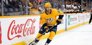 Nashville Predators forward Jonathan Marchessault skating with the puck in a yellow Predators jersey during an NHL game.