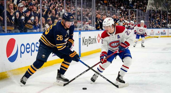 Montreal Canadiens Cole Caufield battles Buffalo Sabres Rasmus Dahlin for a loose puck during 2026 NHL Playoffs action at KeyBank Center.