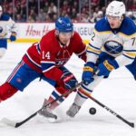 ction shot from the 2026 NHL Playoffs showing Montreal Canadiens forward Nick Suzuki (#14) battling for the puck with a stick check against Buffalo Sabres forward Tage Thompson (#72) during an intense game.