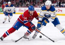 ction shot from the 2026 NHL Playoffs showing Montreal Canadiens forward Nick Suzuki (#14) battling for the puck with a stick check against Buffalo Sabres forward Tage Thompson (#72) during an intense game.