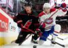 Montreal Canadiens and Carolina Hurricanes players in a fierce board battle during Game 1 of the 2026 NHL Eastern Conference Finals.