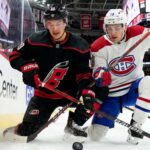 Montreal Canadiens and Carolina Hurricanes players in a fierce board battle during Game 1 of the 2026 NHL Eastern Conference Finals.