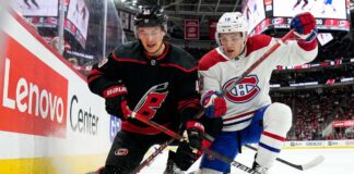 Montreal Canadiens vs Carolina Hurricanes Game 1: TV Channels & Odds Montreal Canadiens and Carolina Hurricanes players in a fierce board battle during Game 1 of the 2026 NHL Eastern Conference Finals.