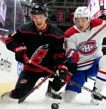 Montreal Canadiens and Carolina Hurricanes players in a fierce board battle during Game 1 of the 2026 NHL Eastern Conference Finals.