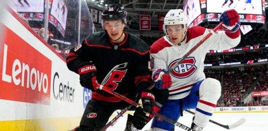 Montreal Canadiens vs Carolina Hurricanes Game 1: TV Channels & Odds Montreal Canadiens and Carolina Hurricanes players in a fierce board battle during Game 1 of the 2026 NHL Eastern Conference Finals.