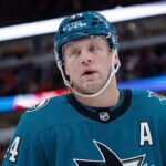 Toronto Maple Leafs & San Jose Sharks: Morgan Rielly Trade Rumors A conceptual image of long-time Toronto Maple Leafs defenseman Morgan Rielly wearing a teal San Jose Sharks home uniform and helmet, visualizing recent NHL trade rumors.