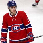 Montreal Canadiens Linked to New Jersey Devils’ Nico Hischier A conceptual jersey swap photograph featuring Nico Hischier on the ice wearing a red Montreal Canadiens home uniform, holding a stick, with number 13 on his blue CCM helmet.