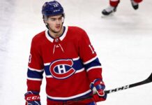 Montreal Canadiens Linked to New Jersey Devils’ Nico Hischier A conceptual jersey swap photograph featuring Nico Hischier on the ice wearing a red Montreal Canadiens home uniform, holding a stick, with number 13 on his blue CCM helmet.