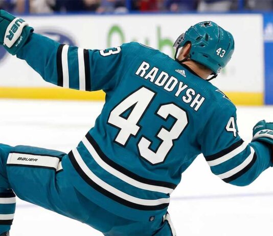 San Jose Sharks free agency target defenseman Darren Raddysh celebrating a goal in a conceptual teal home uniform on the ice with his stick raised.