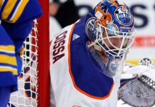 Edmonton Oilers Trade Rumor: Sebastian Cossa From Detroit Red Wings? NHL goaltender Sebastian Cossa pictured in fictional Edmonton Oilers uniform and custom orange and blue goalie mask, visualizing recent trade rumors.