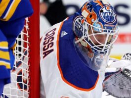 Edmonton Oilers Trade Rumor: Sebastian Cossa From Detroit Red Wings? NHL goaltender Sebastian Cossa pictured in fictional Edmonton Oilers uniform and custom orange and blue goalie mask, visualizing recent trade rumors.