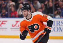 NHL center Shane Wright pictured wearing a Philadelphia Flyers orange home jersey, illustrating potential NHL trade rumors connecting the Seattle Kraken forward to Philadelphia.