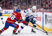 Tampa Bay Lightning forward Brayden Point battles Montreal Canadiens defenseman Lane Hutson for puck control near the boards at the Bell Centre during Game 6 of the 2026 Stanley Cup Playoffs.