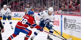 Tampa Bay Lightning forward Brayden Point battles Montreal Canadiens defenseman Lane Hutson for puck control near the boards at the Bell Centre during Game 6 of the 2026 Stanley Cup Playoffs.