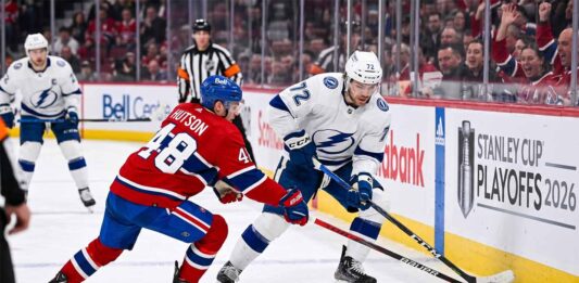 Tampa Bay Lightning forward Brayden Point battles Montreal Canadiens defenseman Lane Hutson for puck control near the boards at the Bell Centre during Game 6 of the 2026 Stanley Cup Playoffs.