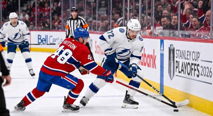 tampa-bay-lightning-montreal-canadiens-game-6-playoffs-2026 Tampa Bay Lightning forward Brayden Point battles Montreal Canadiens defenseman Lane Hutson for puck control near the boards at the Bell Centre during Game 6 of the 2026 Stanley Cup Playoffs.
