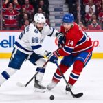 Nikita Kucherov (#86) of the Tampa Bay Lightning and Nick Suzuki (#14) of the Montreal Canadiens battle intensely for the puck during Game 6 of their Eastern Conference Quarterfinal series at Centre Bell in Montreal.