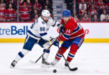 Nikita Kucherov (#86) of the Tampa Bay Lightning and Nick Suzuki (#14) of the Montreal Canadiens battle intensely for the puck during Game 6 of their Eastern Conference Quarterfinal series at Centre Bell in Montreal.