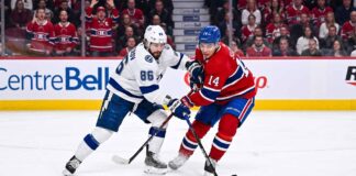 Nikita Kucherov (#86) of the Tampa Bay Lightning and Nick Suzuki (#14) of the Montreal Canadiens battle intensely for the puck during Game 6 of their Eastern Conference Quarterfinal series at Centre Bell in Montreal.