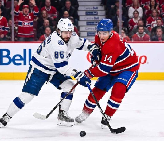 Nikita Kucherov (#86) of the Tampa Bay Lightning and Nick Suzuki (#14) of the Montreal Canadiens battle intensely for the puck during Game 6 of their Eastern Conference Quarterfinal series at Centre Bell in Montreal.