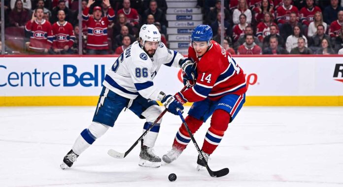 Nikita Kucherov (#86) of the Tampa Bay Lightning and Nick Suzuki (#14) of the Montreal Canadiens battle intensely for the puck during Game 6 of their Eastern Conference Quarterfinal series at Centre Bell in Montreal.
