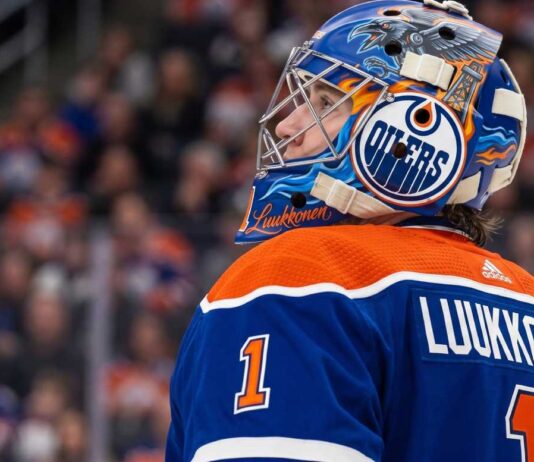 Edmonton Oilers Trade Rumors: Ukka-Pekka Luukkonen Sabres Deal A close-up profile view of Buffalo Sabres goaltender Ukko-Pekka Luukkonen, wearing his custom-painted goalie mask and blue jersey with 'LUUKKONEN' visible on the back. This image is used in an analysis of a potential trade linking him to the Edmonton Oilers.