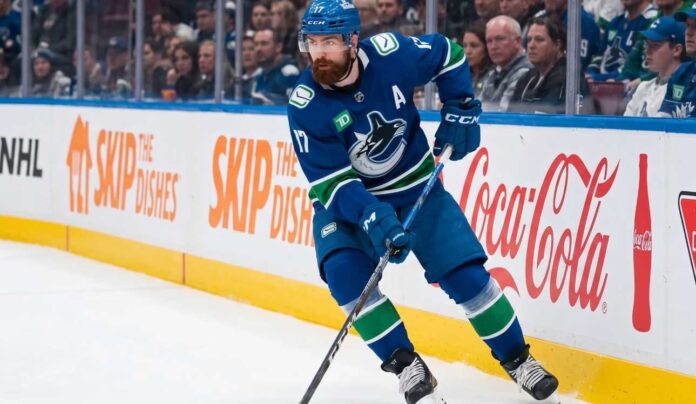 Vancouver Canucks defenseman Filip Hronek skating with the puck looking for a passing lane during an NHL game at Rogers Arena.