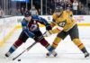 An action shot of Nathan MacKinnon (#29) of the Colorado Avalanche battling Shea Theodore (#27) of the Vegas Golden Knights in a crucial playoff game face-off.
