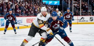 How to Watch Vegas Golden Knights at Colorado Avalanche Game 1 Tonight An intense photo capturing a puck battle between superstars Jack Eichel (#15) of the Vegas Golden Knights and Nathan MacKinnon (#29) of the Colorado Avalanche during Game 1 of the 2026 Western Conference Finals at Ball Arena. The background features the NHL Western Conference Finals sign and cheering fans.