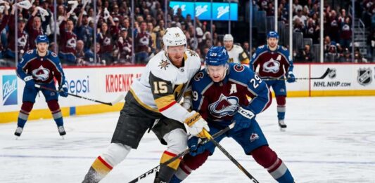 How to Watch Vegas Golden Knights at Colorado Avalanche Game 1 Tonight An intense photo capturing a puck battle between superstars Jack Eichel (#15) of the Vegas Golden Knights and Nathan MacKinnon (#29) of the Colorado Avalanche during Game 1 of the 2026 Western Conference Finals at Ball Arena. The background features the NHL Western Conference Finals sign and cheering fans.