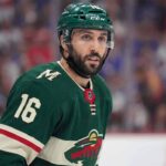 Minnesota Wild Trade Rumors: Will They Acquire Vincent Trocheck? A close-up portrait of Vincent Trocheck wearing a forest green Minnesota Wild home jersey with the number 16, illustrating the recent trade rumors connecting him to the team from the New York Rangers.