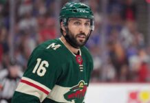A close-up portrait of Vincent Trocheck wearing a forest green Minnesota Wild home jersey with the number 16, illustrating the recent trade rumors connecting him to the team from the New York Rangers.