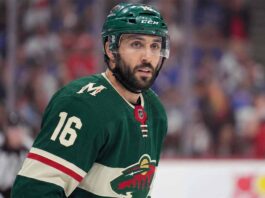 A close-up portrait of Vincent Trocheck wearing a forest green Minnesota Wild home jersey with the number 16, illustrating the recent trade rumors connecting him to the team from the New York Rangers.
