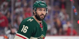 A close-up portrait of Vincent Trocheck wearing a forest green Minnesota Wild home jersey with the number 16, illustrating the recent trade rumors connecting him to the team from the New York Rangers.