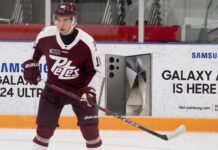 A photograph of Peterborough Petes forward Adam Novotny (#16) skating with a powerful stance on the ice.