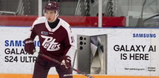 A photograph of Peterborough Petes forward Adam Novotny (#16) skating with a powerful stance on the ice.